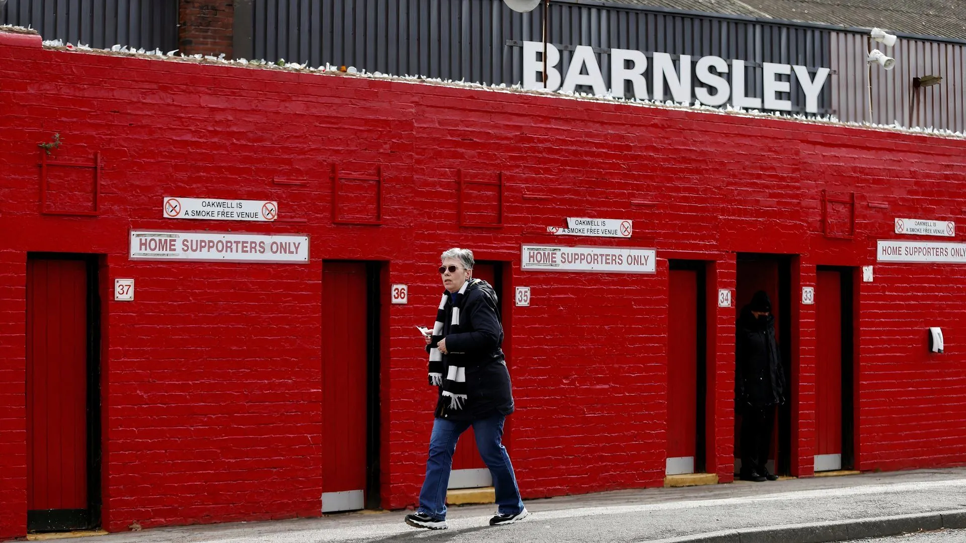 Một người hâm mộ đứng ngoài sân vận động Oakwell của Barnsley