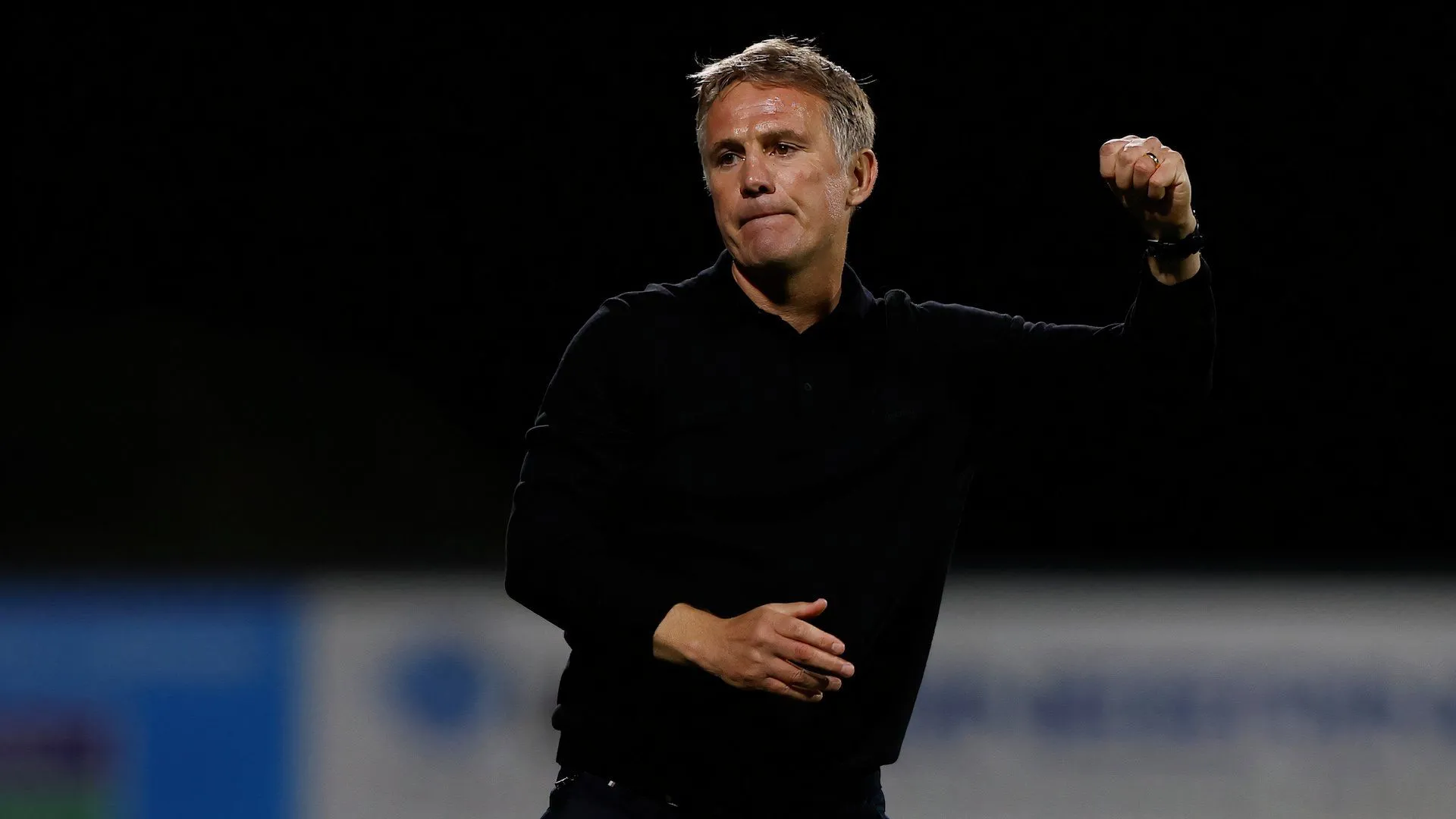 Phil Parkinson với nắm đấm quyết tâm, biểu thị sự tập trung và ý chí chiến thắng trong vai trò huấn luyện viên Wrexham